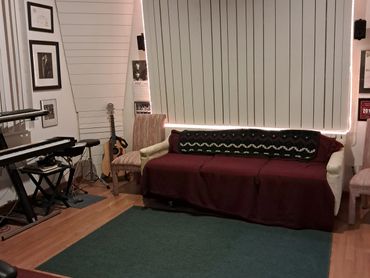 Studio lounge with burgundy sofa and keyboard