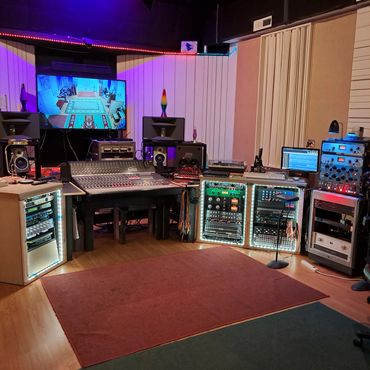 Control room with mixing console and purple lighting